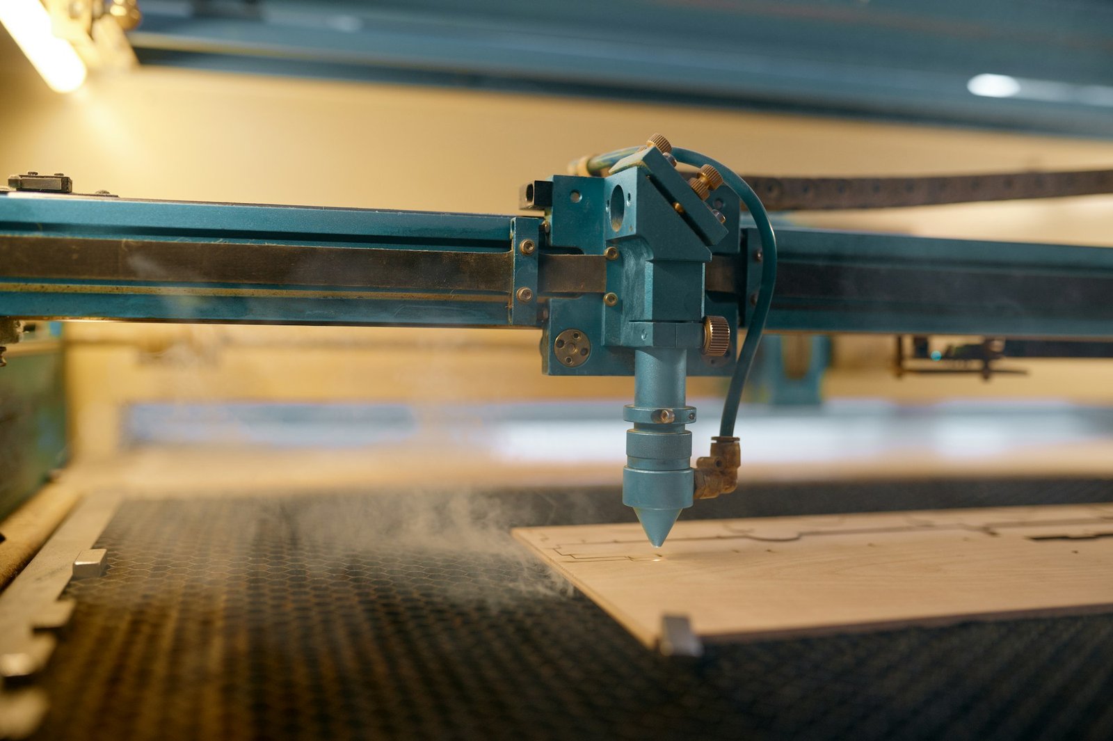 Closeup automated CNC laser machine operating with wooden plank
