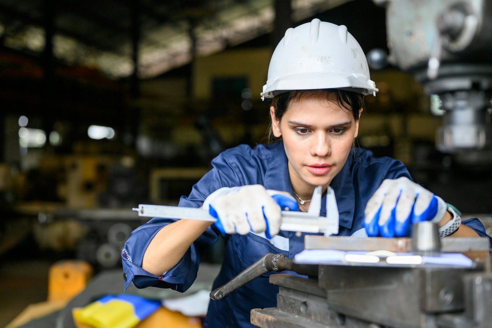 Female worker with safety hard hat working at manufacturing